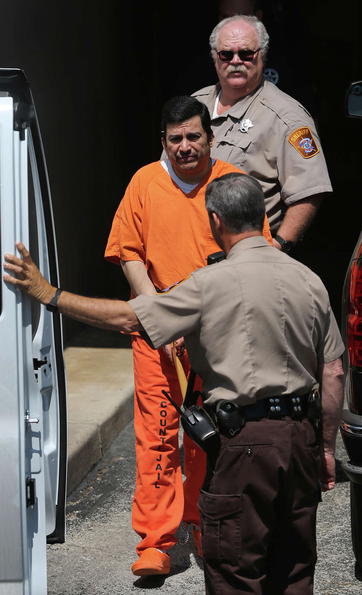Ezequiel Rodriguez, (center, wearing orange jumpsuit) a reported associate of the Zetas, is escorted out of the back of the John H. Wood Federal Courthouse Tuesday April 7, 2015 in San Antonio, Texas. Rodriguez allegedly booked music acts for the cartel and was arrested in 2013 on a drug charge after being a fugitive for a while.