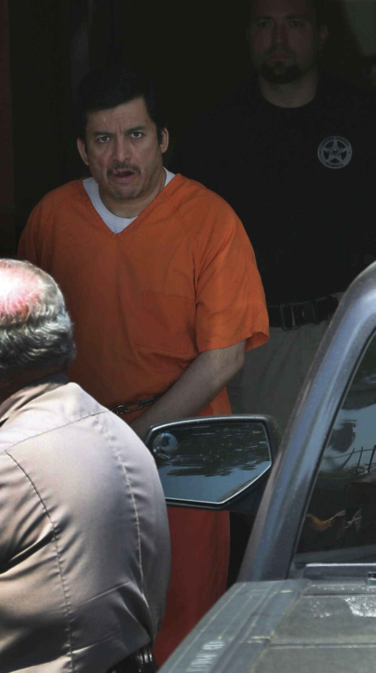 Ezequiel Rodriguez, (center, wearing orange jumpsuit) a reported associate of the Zetas, is escorted out of the back of the John H. Wood Federal Courthouse Tuesday April 7, 2015 in San Antonio, Texas. Rodriguez allegedly booked music acts for the cartel and was arrested in 2013 on a drug charge after being a fugitive for a while.
