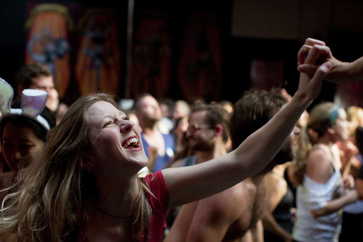 Marnie Brumder grabs a dancer's hand onstage at Daybreaker, a device-free dance party hosted by Digital Detox and Camp Grounded, at Inner Mission in San Francisco, Calif. on Thursday, April 9, 2015.