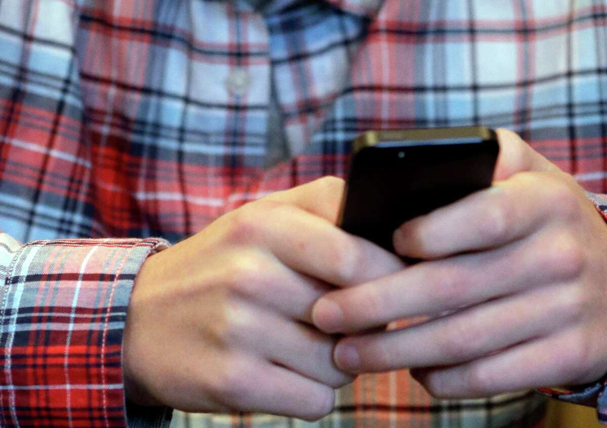 A youth checks his smartphone in Glenview, Ill. Local police may be tracking your cellphone with new technology and should be thoughtful about how it's used. ﻿