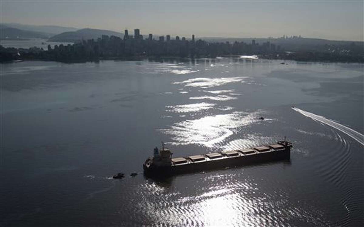Spill response boats work to contain fuel leaking from the bulk carrier cargo ship Marathassa, anchored on English Bay, Thursday, April 9, 2015, in Vancouver, British Columbia. Slow spill response allowed oil to reach beaches in Vancouver and West Vancouver.  Critics of a proposed pipeline and oil export terminal fear what would happen were an oil tanker to rupture. ( Darryl Dyck)