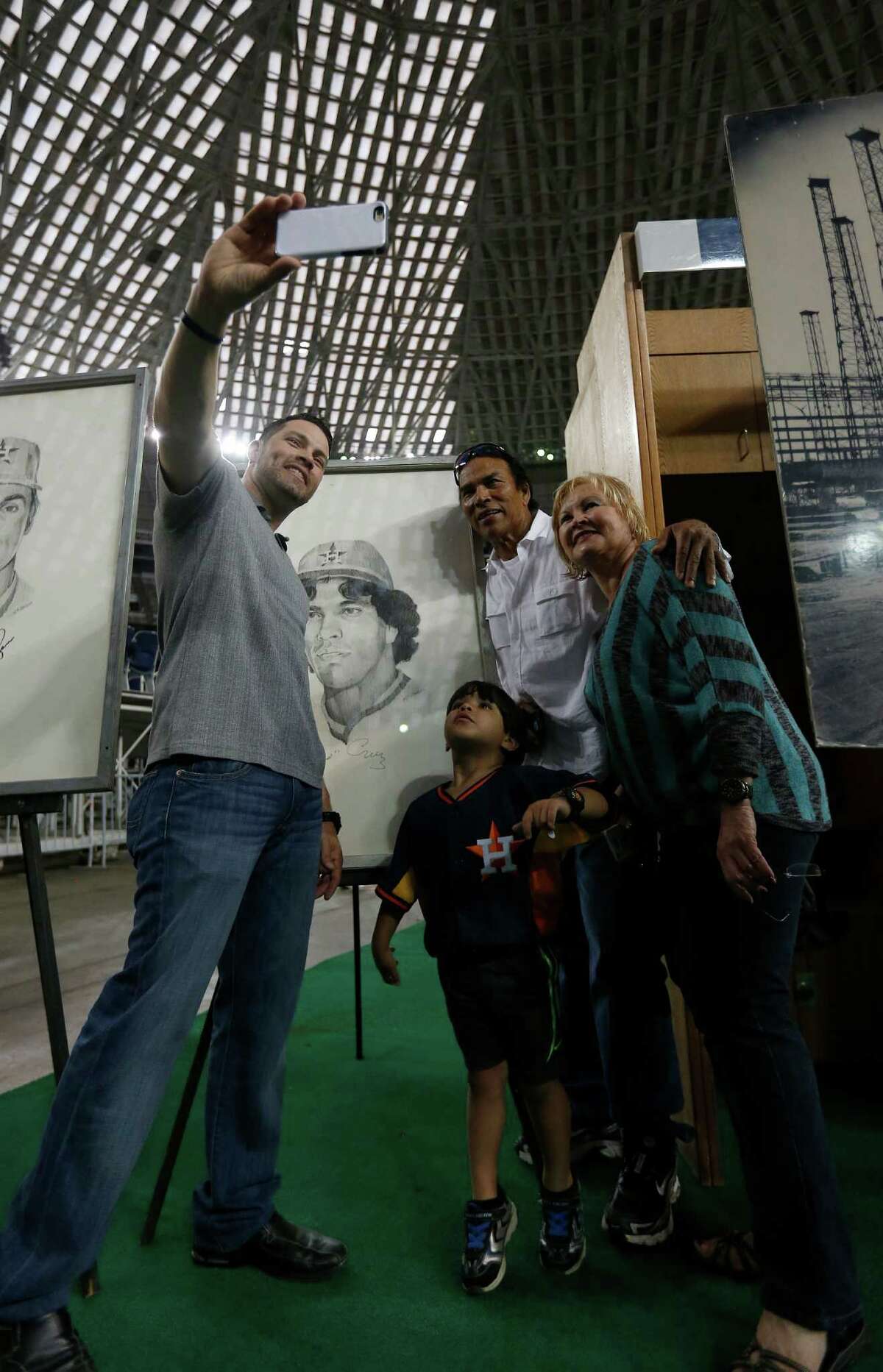 Jose Cruz and his family, Enrique Cruz, wife Zoraida and grandson Diego Macias take photos with a drawing of Jose inside of the Astrodome during the 50th anniversary of the first Opening Day in the Astrodome, on Thursday, April 9, 2015, in Houston.