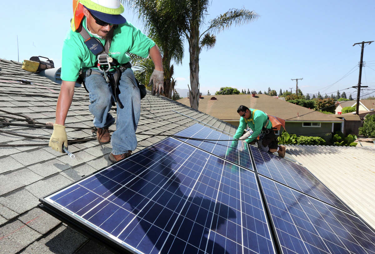 Workers from SolarCity install solar panels on a home in Camarillo (Ventura County).