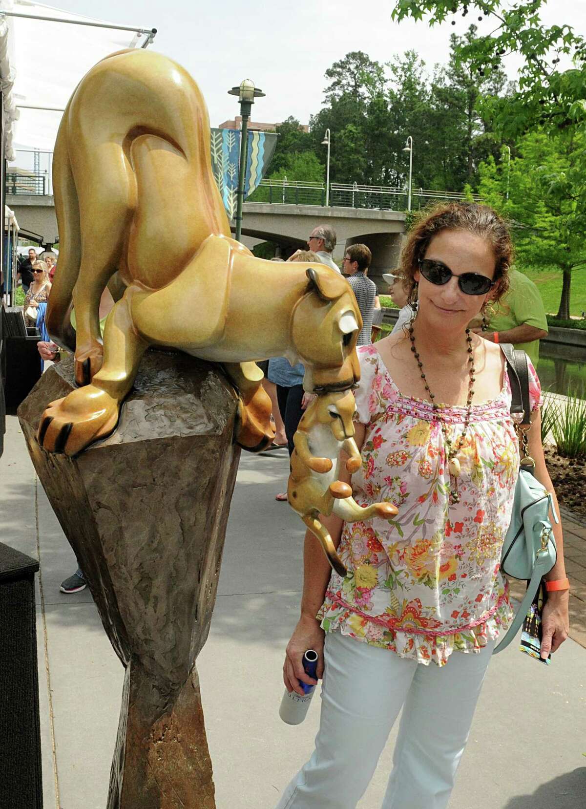 Ivette Bear, of The Woodlands, admires a bronze sculpture of a cougar and her cub during the 10th annual The Woodlands Waterway Arts Festival on The Woodlands Waterway and Town Green Park. 200 artists from across the nation were featured at the festival.