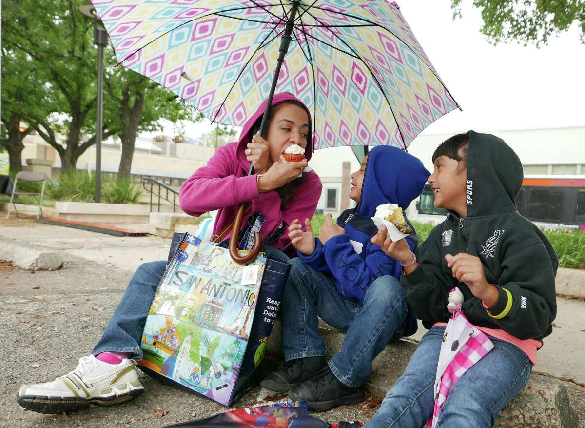 The rain doesn’t faze Jacqueline Tovar and her children, Diego, 6, and Celeste, 9, at the San Antonio Book Festival.