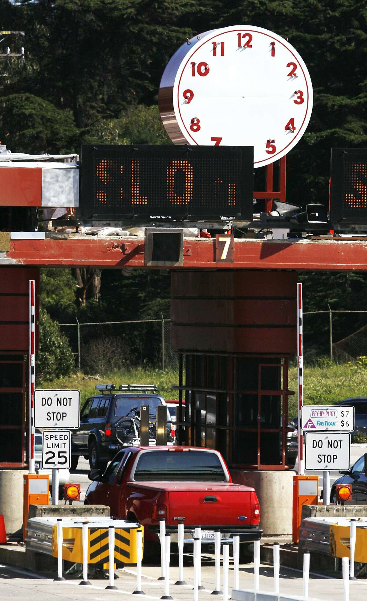Cars pass under the clock on the toll plaza at the south end of the Golden Gate Bridge on Sunday, April 12, 2015.