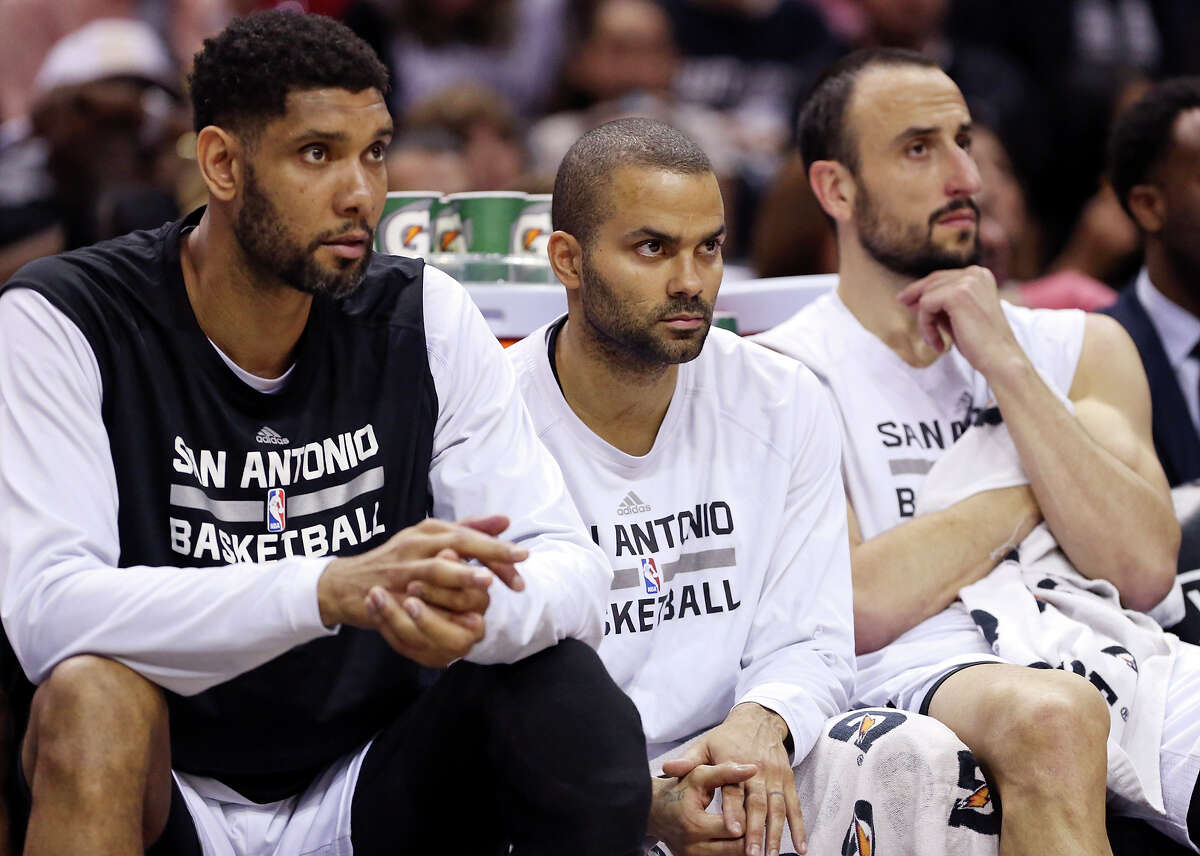 San Antonio Spurs' Tim Duncan (from left), Tony Parker, and Manu Ginobili watch first half action against the Phoenix Suns from the bench Sunday April 12, 2015 at the AT&T Center.