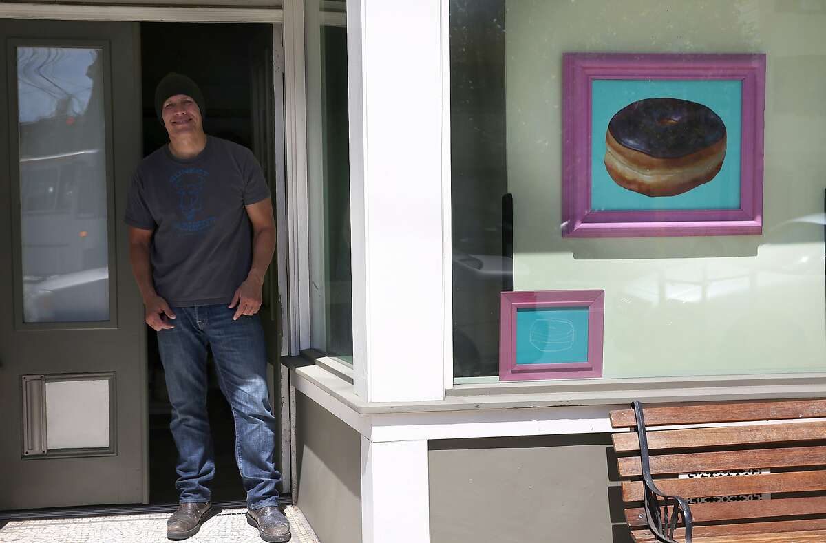 Still life painter Jay Mercado has a chocolate donut painting displayed in the window of his studio in San Francisco, California, on Friday, April 10, 2015. Genentech just bought six of them for its new headquarters building.