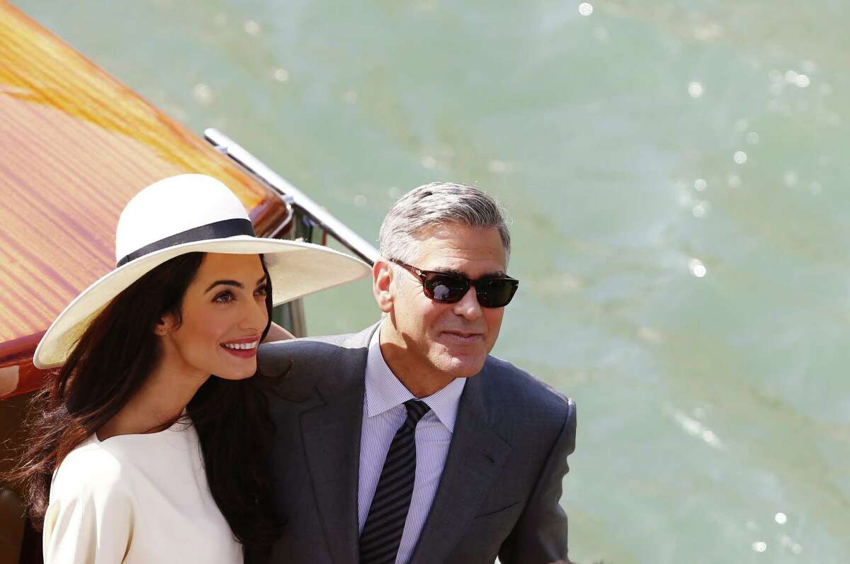 TOPSHOTS -- AFP PICTURES OF THE YEAR 2014 -- US actor George Clooney and British lawyer Amal Alamuddin leave the palazzo Ca Farsetti on a taxi boat on September 29, 2014 in Venice, after a civil ceremony to officialise their wedding. AFP PHOTO / PIERRE TEYSSOTPIERRE TEYSSOT/AFP/Getty Images ORG XMIT: MER2015041313471660