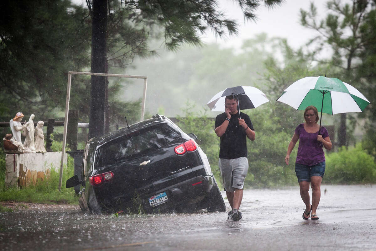 Telge Road near Spring Cypress Road Raymond Valenta, left, and his mother Koran Kaptchinskie phone for help after their car was stranded in high water on Telge Rd. near Spring Cypress Rd. in northwest Houston, Thursday, July 12, 2012, in Houston. ( Michael Paulsen / Houston Chronicle )