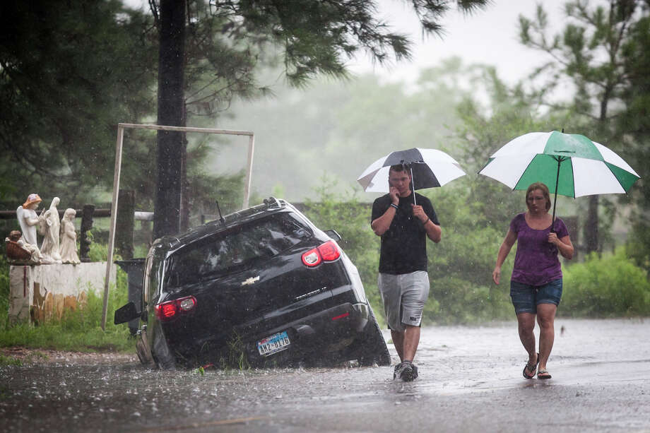 Telge Road near Spring Cypress RoadRaymond Valenta, left, and his mother Koran Kaptchinskie phone for help after their car was stranded in high water on Telge Rd. near Spring Cypress Rd. in northwest Houston, Thursday, July 12, 2012, in Houston. ( Michael Paulsen / Houston Chronicle ) Photo: Michael Paulsen, Houston Chronicle File / © 2012 Houston Chronicle