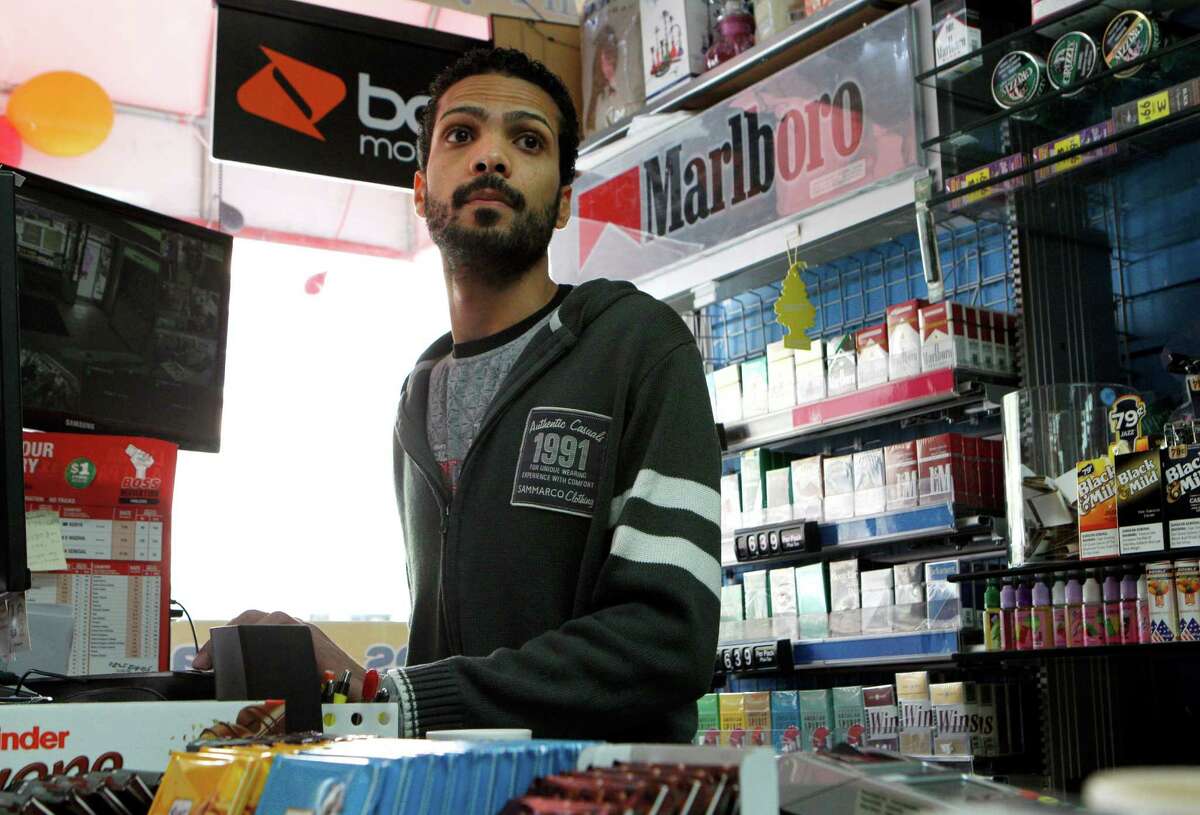 Cashier Imad Awad checks on customers at GSM/Fine Foods, Monday, April 13, 2015, in Berkeley, Calif. A proposed ordinance would ban the sale of tobacco products within 1,000 feet of schools or parks. The store is located near Berkeley High School and the ordinance could force the business to close as tobacco products are a large source of the store's income.