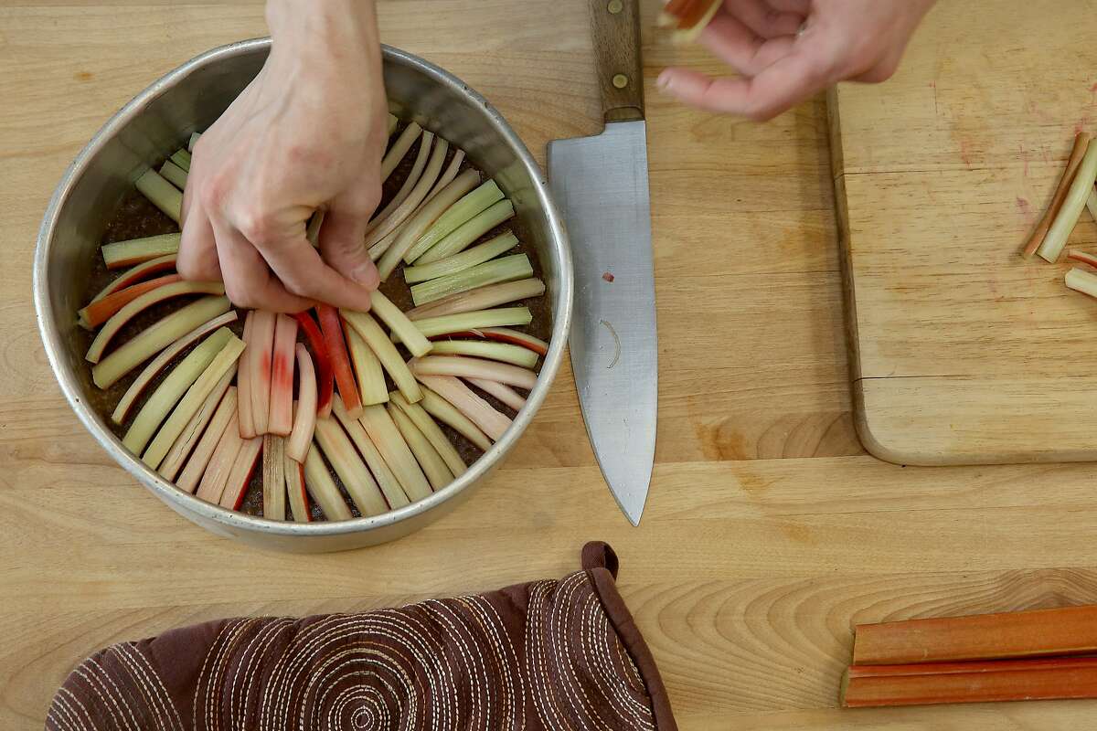 Chef/owner Stacie Pierce of Little Bee Baking lays rhubarb at the bottom of a pan for an upside-down cake in her home kitchen in San Francisco, California, on Monday, April 13, 2015.