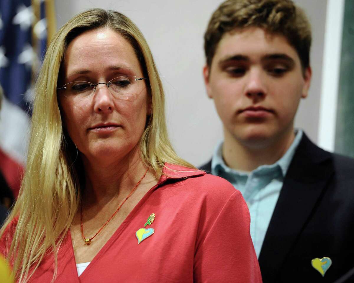Scarlett Lewis, mother of Sandy Hook School shooting victim Jesse Lewis, left, and son JT listen during a news conference at the Legislative Office Building, Monday, April 13, 2015, in Hartford, Conn. The Connecticut congressional delegation is backing federal legislation that would honor Jesse Lewis and provide expanded support to train teachers in social and emotional learning. (AP Photo/Jessica Hill)