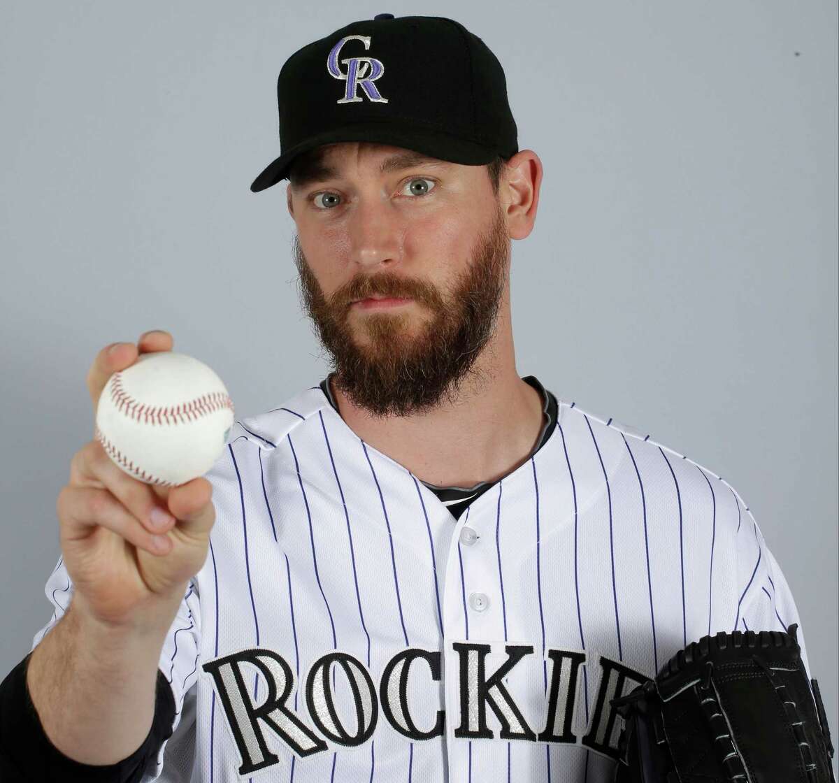 FILE - In a March 2015 file photo, John Axford of the Colorado Rockies baseball team poses for a photo in Scottsdale, Ariz. Axford's 2-year-old son is improving following a rattlesnake bite. Jameson Axford remained hospitalized for an eighth straight day, but Axford said Wednesday, Apri his son was able to sleep through the night as he deals with pain. Doctors have saved his right foot, but there is fear one of his toes may need to be amputated. "It's looking better," Axford said. "We're going by doctors' orders. They know more than we do. We're going to trust them to heal him the best way possible." (AP Photo/Darron Cummings, File)