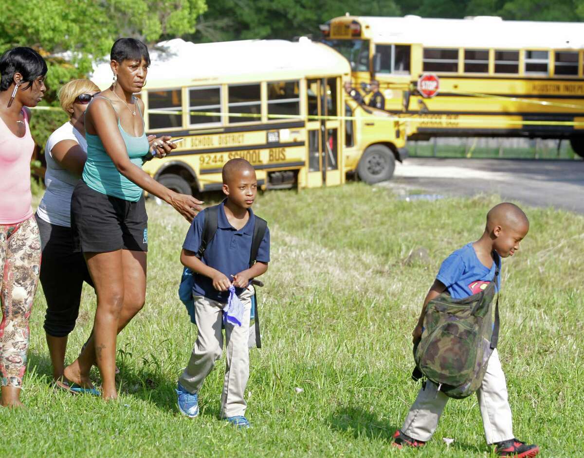 Ma'lique Brown, 7, right, and his brother, ﻿Ja'Kal Brown, 8, are led away by their grandmother Marilyn Williams after the﻿ HISD bus crash.