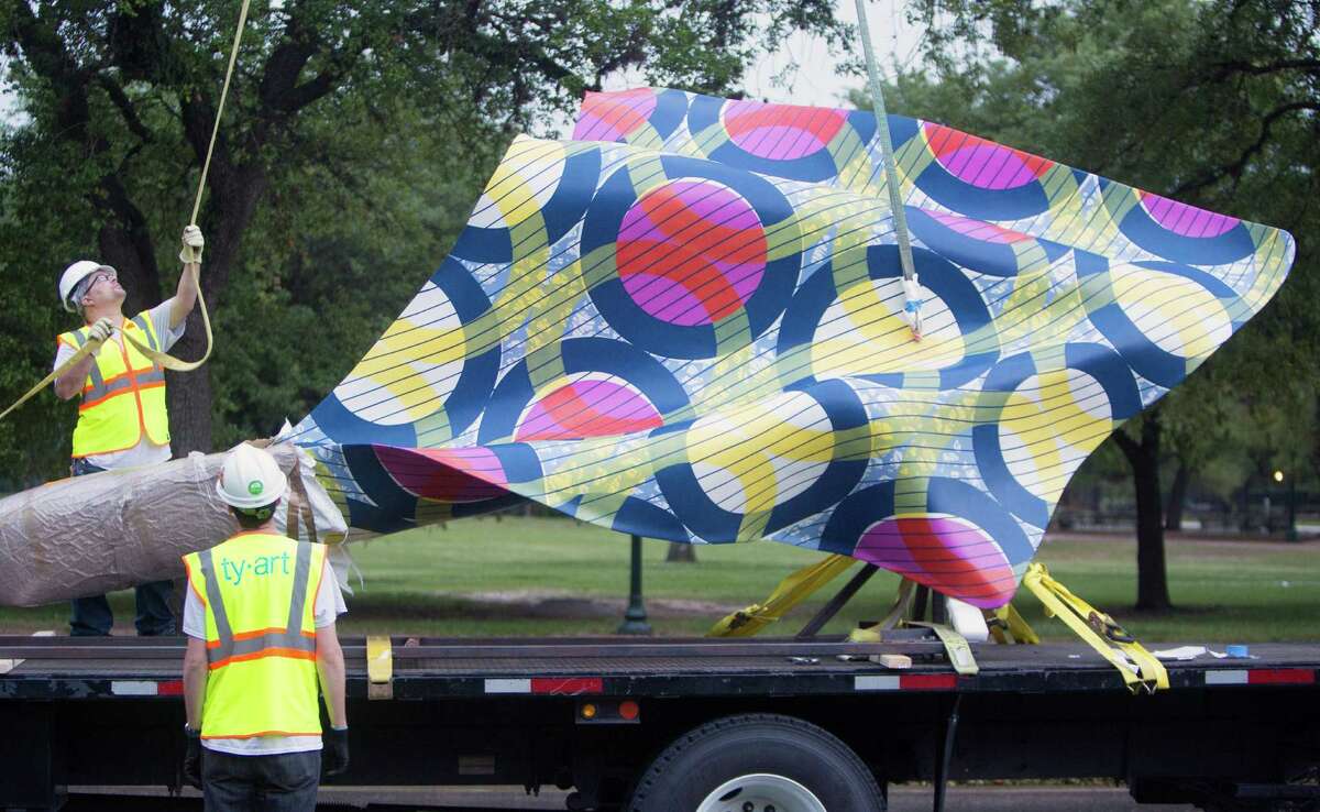 Crew members with TYart prepare to install Wind Sculpture IV by London-based artist Yinka Shonibare, at Hermann Park, Tuesday, April 14, 2015, in Houston. The sculpture, which is nearly 20 feet high and 11 feet wide at its widest point, captures the movement of a billowing bolt of fabric, the ripple seemingly paused in time. Wind Sculpture IV is one work in Shonibare's series inspired by ship sails. (Cody Duty / Houston Chronicle)