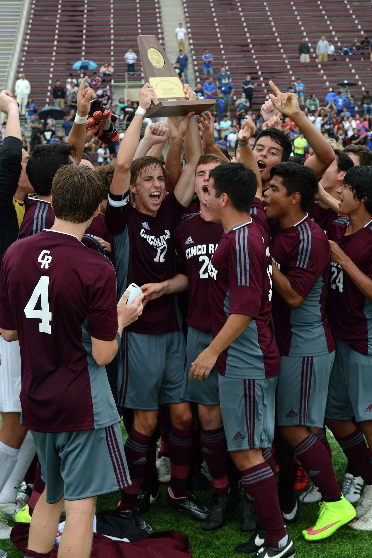 Cinco Ranch senior defender Chris Stamm, center, hoists the Cougars' trophy after their 2-1 win over the Aldine Mustangs in their Region III Class 6A Boys Soccer regional final.