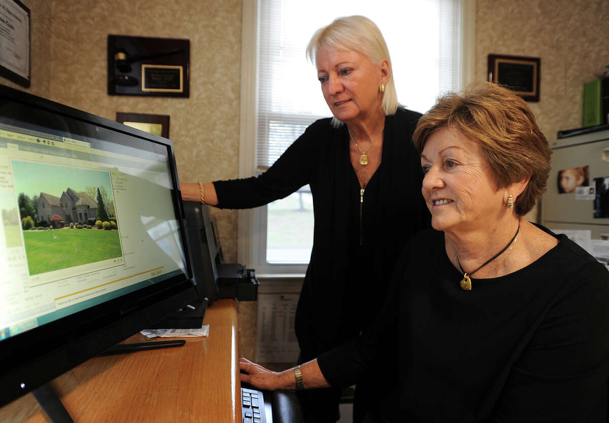 Linda Schauwecker, left, and Susan Coyle, co-owners of Real Estate Two, Inc., pull up some current listings in their office in the Huntington section of Shelton, Conn. on Tuesday, April 14, 2015.