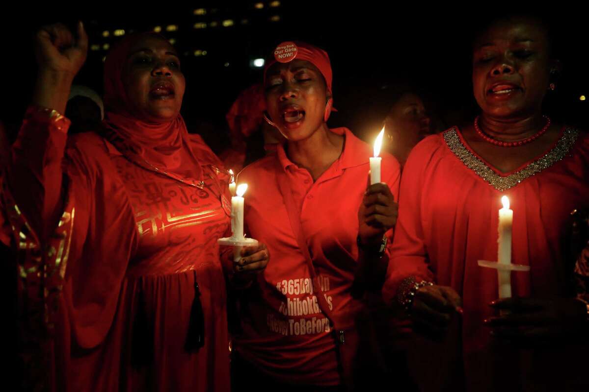 People hold candles as they sing during a vigil to mark the one year anniversary of the abduction of girls studying at the Chibok government secondary school, Abuja, Nigeria, Tuesday, April 14, 2015. On the first anniversary of the day 276 schoolgirls were snatched in the middle of the night as they prepared to write science exams at their boarding school in northeastern Nigeria, President-elect Muhammadu Buhari said he cannot promise to find the 219 who are still missing. (AP Photo/Sunday Alamba)