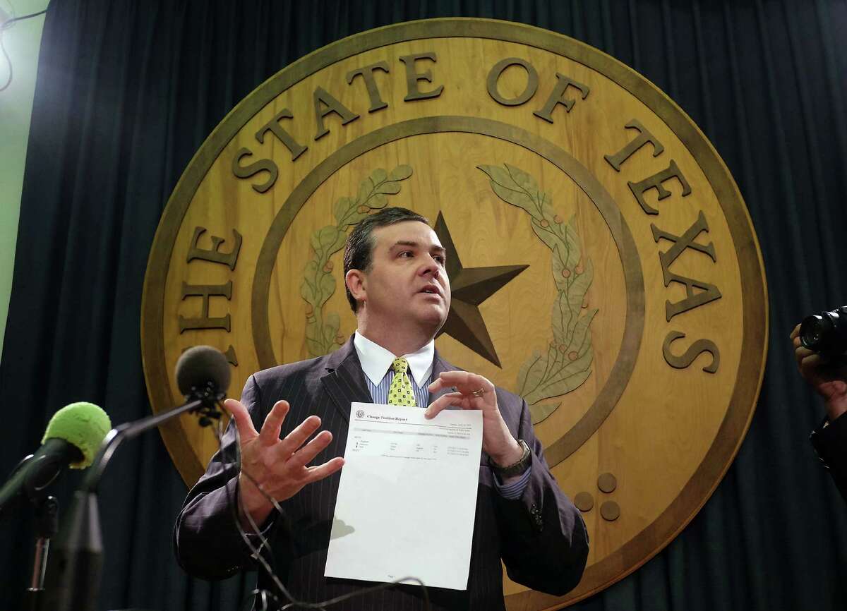 Rep. Trey Martinez Fischer, D-San Antonio, center left, smiles as his point of order motion was about to be sustained postponing an open carry bill on the House floor ﻿in Austin﻿ Tuesday﻿. At right, Rep. Larry Phillips, R-Sherman, holds up the change position report with the errors used as a point of order to try to delay ﻿the bill.﻿