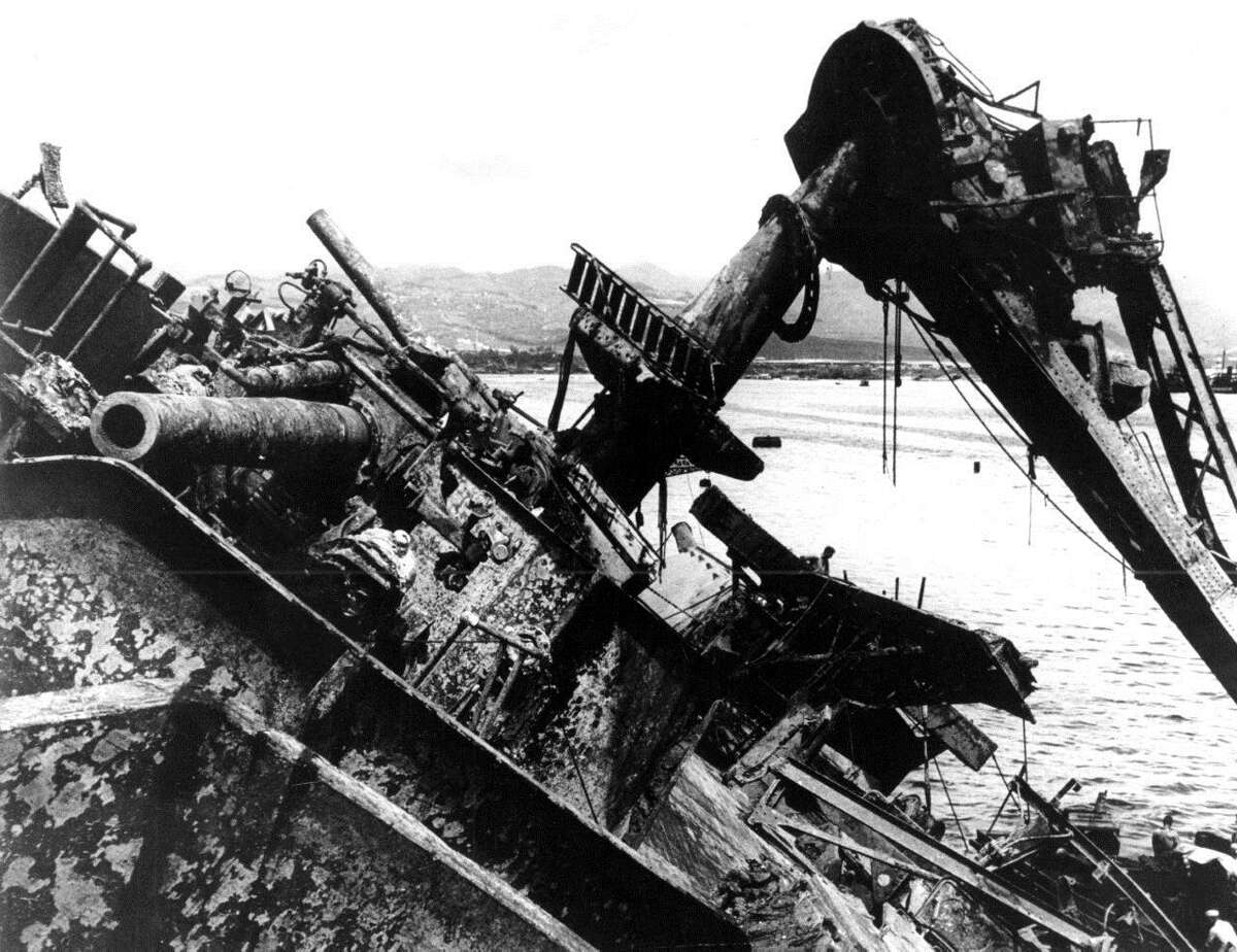 FILE - In this May 24, 1943 file photo, the deck of the capsized battleship USS Oklahoma breaks water at Pearl Harbor in Honolulu, Hawaii. The Pentagon says it will disinter and try to identify the remains of up to 388 unaccounted for sailors and Marines killed when the USS Oklahoma sank in the 1941 Japanese bombing of Pearl Harbor.