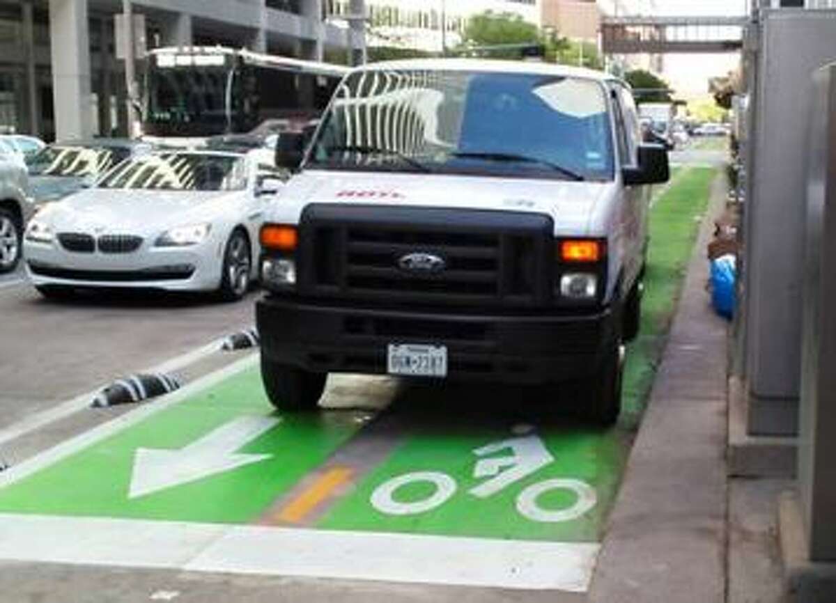 Houston's first protected bike lane on Lamar downtown has met with a few glitches, such as vehicles illegally parked in the bike lane. (Photo: Courtesy of BikeHouston)