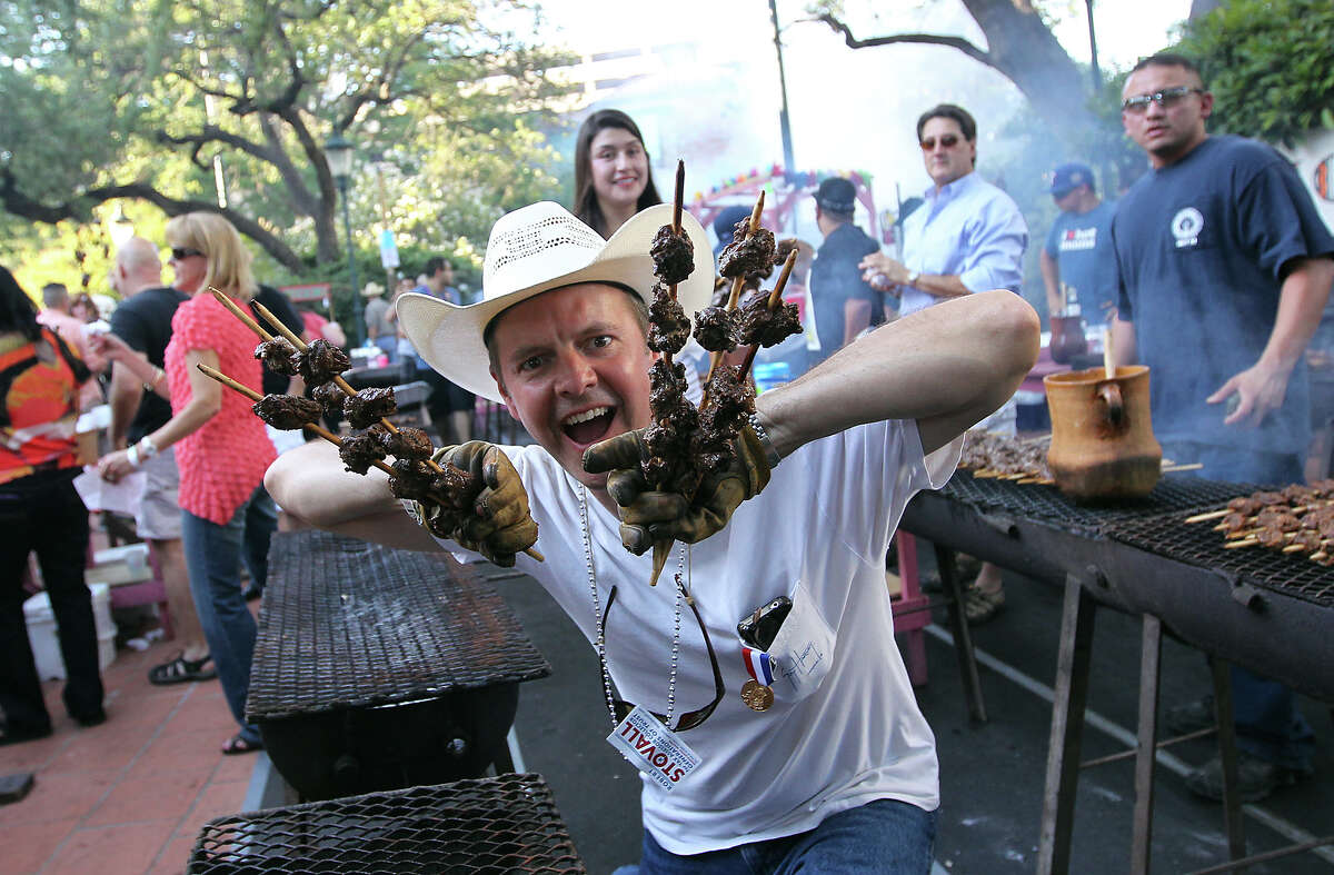 Peter Rockwood has a little fun with skewers of anticuchos before serving them up to guests on the first night of a Night in Old San Antonio on Apr. 24, 2012. Several thousand of the beefy treats will be served up before the night is over.