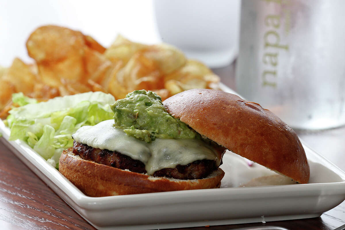 The Fresno Burger is made with a wood-fired, hand formed pork patty topped with melted provolone and housemade guacamole at Napa Flats. Homemade chips accompany the burgers.