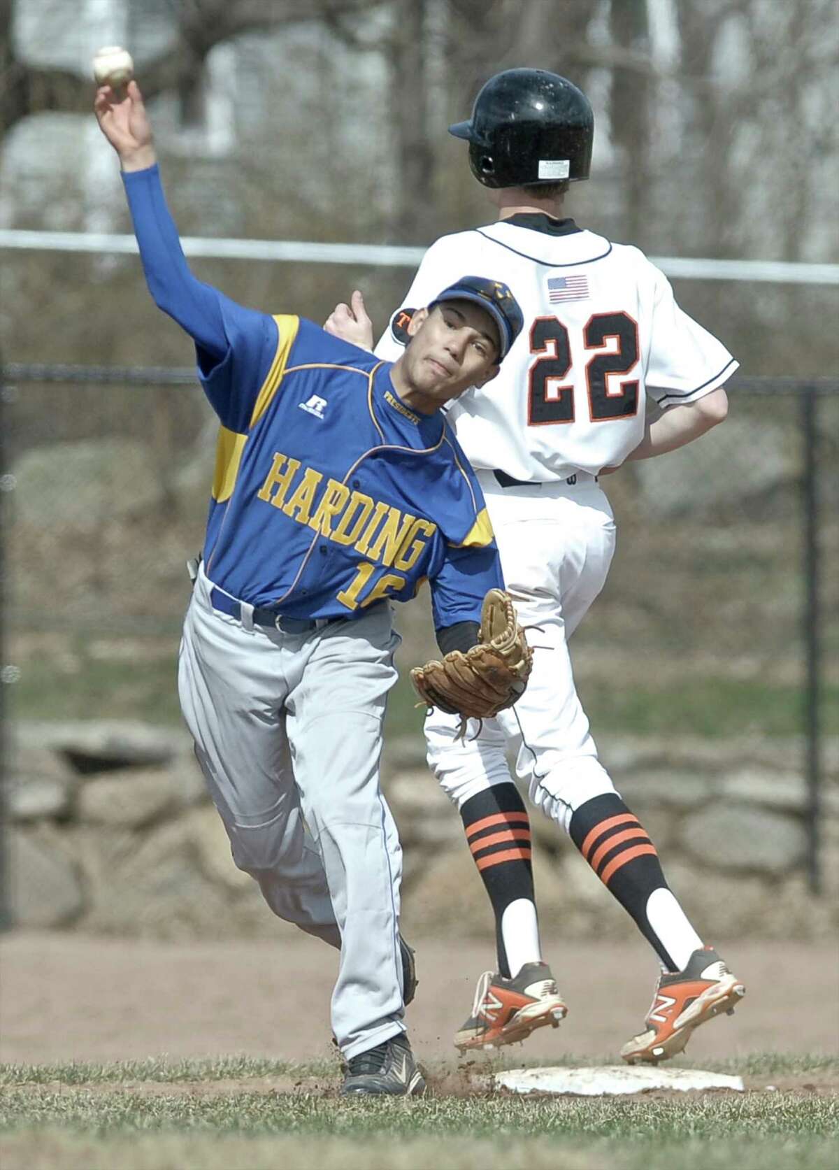 Harding's L. Hernandez (16) makes the throw to first but misses the double play after putting out Ridgefield's Craig Burke (22) at third during the boys high school baseball game between Harding and Ridgefield high schools, played at Ciuccoli Field in Ridgefield, Conn, on Wednesday, April 15, 2015.