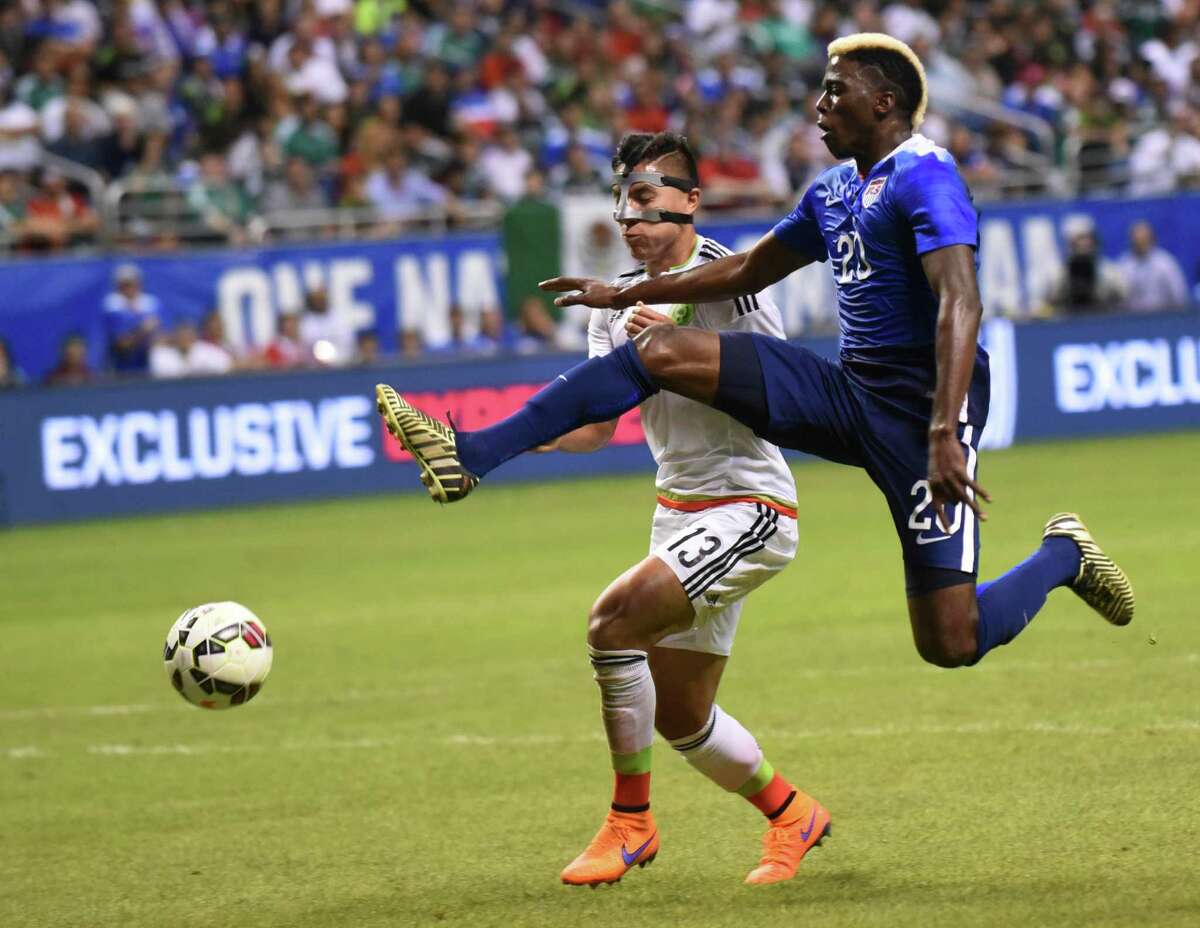 Gyasi Zardes of the USA kicks a shot on goal as Cirilo Saucedo of Mexico defends during an international friendly match at the Alamodome on Wednesday, April 15, 2015.
