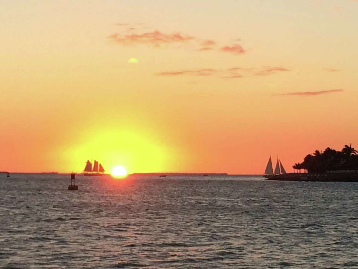 The sun descends behind the horizon off the coast of Key West, next to the Sunset Key in Florida. A daily Sunset Celebration marks the occasion in the southernmost island of the Keys.