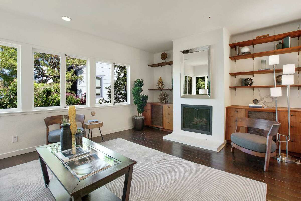 The living room features hardwood flooring and built-in shelving on both sides of the fireplace.