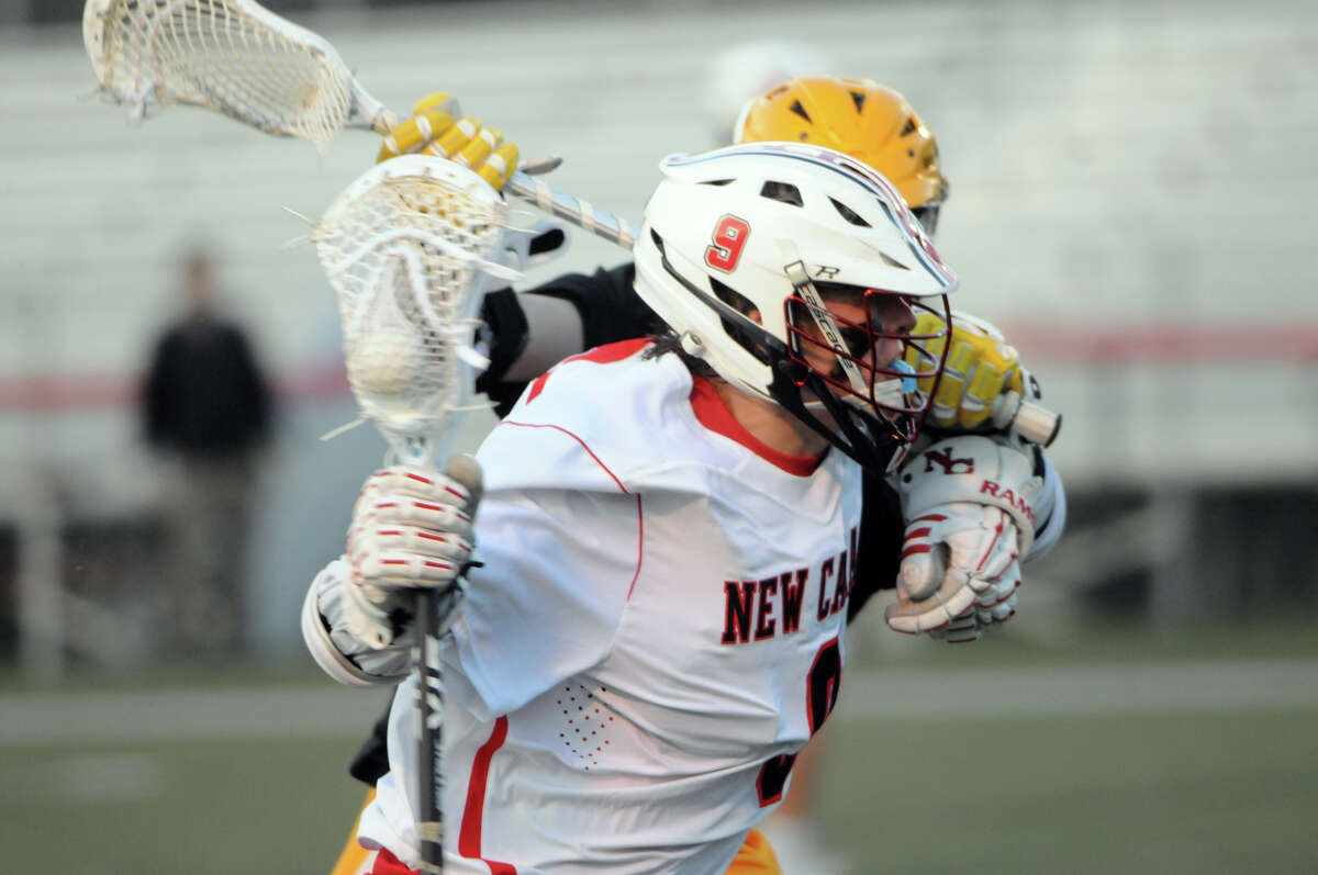 New Canaan's Owen Toland pushes past a Bruins defender as the Rams host the Brunswick Bruins in a boys lacrosse game in New Canaan, Conn., April 16, 2015.