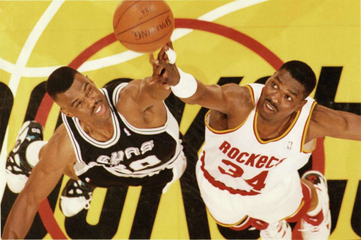 San Antonio Spurs’ David Robinson goes up for the opening tip-off against Houston Rockets’ Hakeem Olajuwon in the Houston Summit, April 9, 1994.