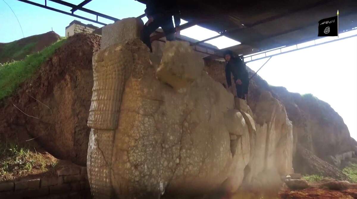 An image from video on a social media account affiliated with ISIS the Islamic State group on Thursday, Feb. 26, 2015, which has been verified and is consistent with other AP reporting, militants destroy winged-bull Assyrian protective deity in the Ninevah Museum in Mosul, Iraq. The extremist group has destroyed a number of shrines --including Muslim holy sites -- in order to eliminate what it views as heresy. The militants are also believed to have sold ancient artifacts on the black market in order to finance their bloody campaign across the region. (AP Photo via militant social media account)