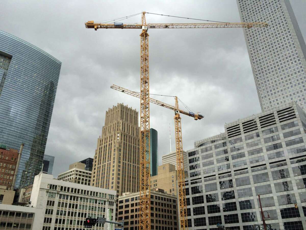 Cranes tower above a downtown skyscraper construction site. The location will house an office tower developed by Hines, which is also building a residential high-rise in nearby Market Square.