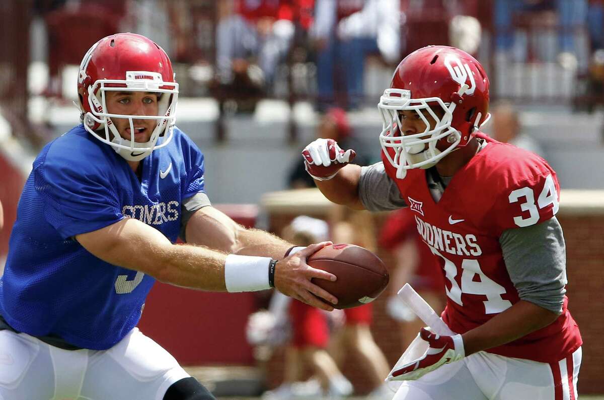 Oklahoma quarterback Trevor Knight hands off the ball to running back Daniel Brooks (34) during the annual Red White spring college football scrimmage in Norman, Okla., on April 11, 2015.