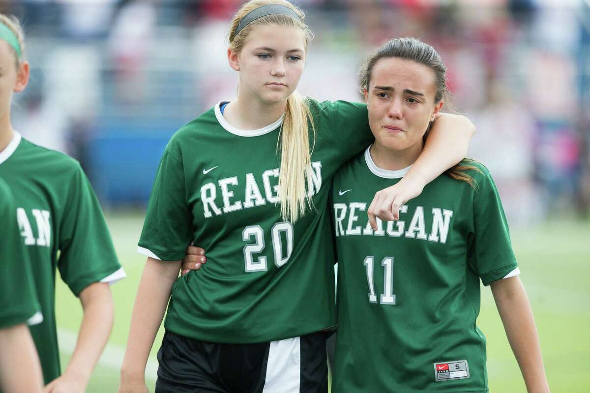 Reagan defender Lydia Jones, left, consoles a teammate after their 0-1 loss to Coppell at the 6A Girls Soccer Semi-Final in Georgetown on Friday April 17, 2015. Julia Robinson/For the Express-News