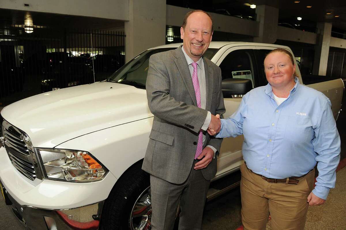 KBR CEO Stuart Bradie congratulates welder Holley Thomas after she won a Dodge Ram 1500 for being named Craft Person of the Year at the KBR Building Thursday April 16, 2015.(Dave Rossman photo)