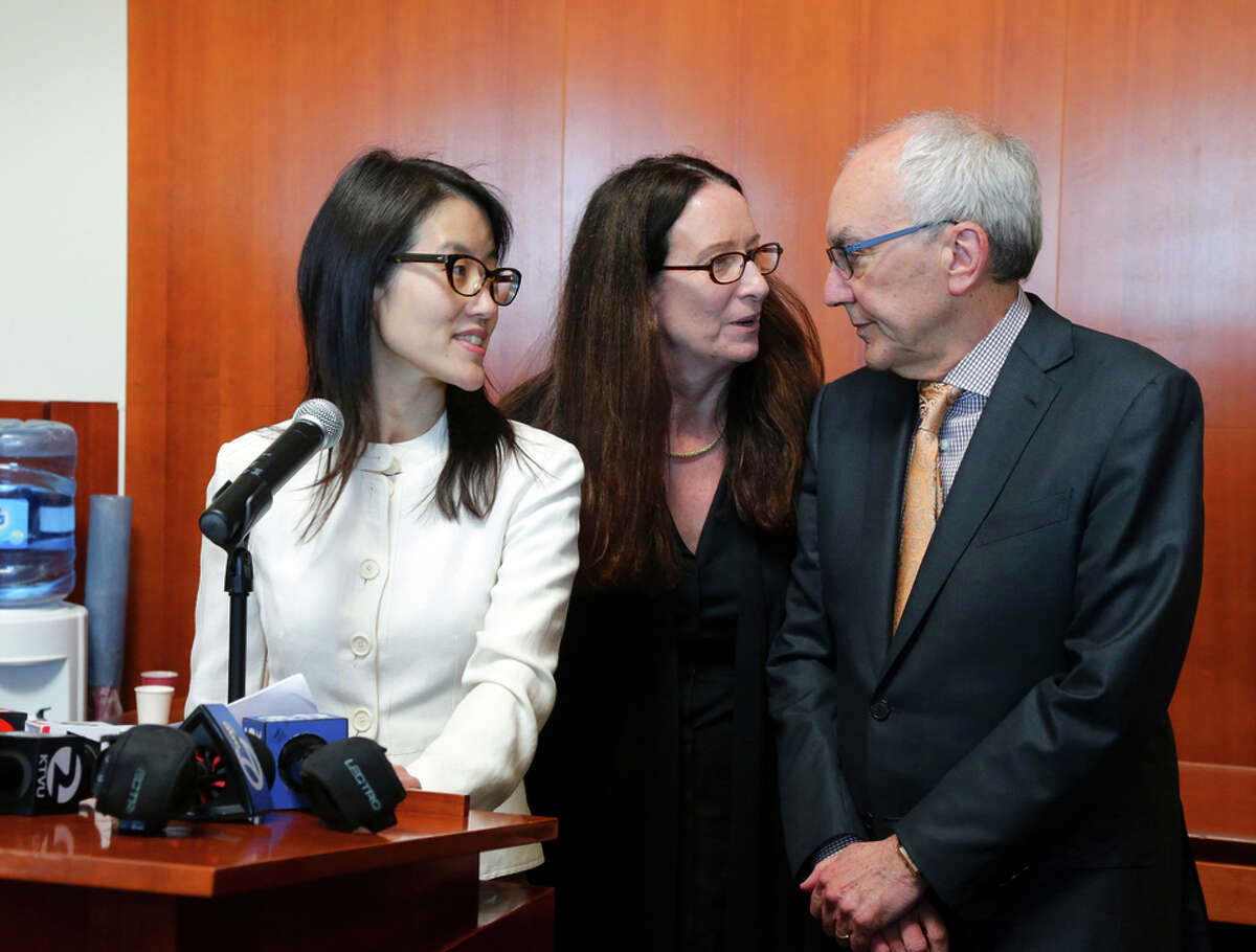 Ellen Pao talks to reporters as her lawyers Therese Lawless and Alan Exelrod stand behind her.