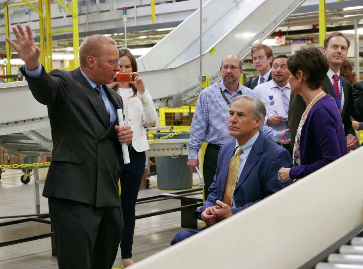 Texas Governor Greg Abbott, seated, takes a tour guided by Mike Roth, vice president of North American operations for Amazon, at the new Amazon Fulfillment Center in Schertz, Texas, on Friday, April 17, 2015.