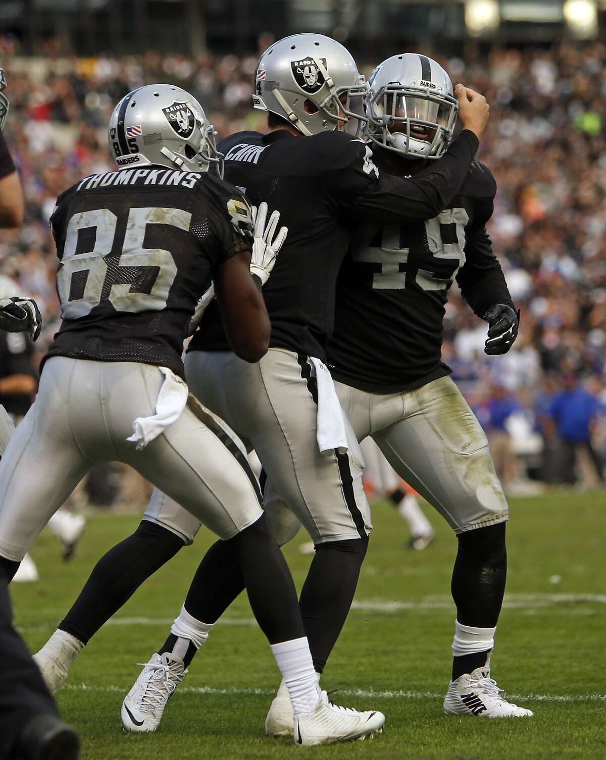 Oakland Raiders' Derek Carr and Kenbrell Thompkins help Jamize Olawale celebrate Olawale's 4th quarter touchdown reception during Raiders' 26-24 win over the Buffalo Bills during NFL game at O.co Coliseum in Oakland, Calif., on Sunday, December 21, 2014.