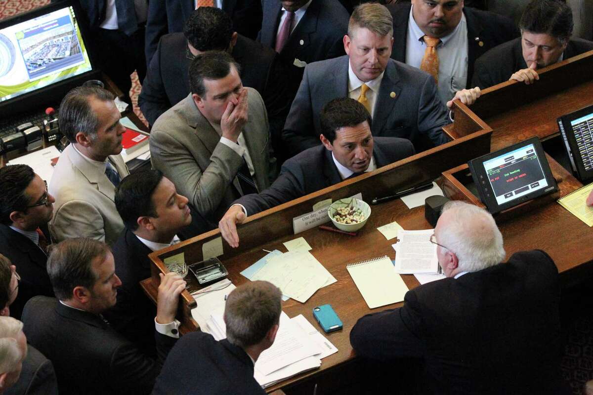Trey Martinez Fischer, center, raises another point of order to Chris Grieser , bottom right corner, while trying to derail HB 910 which would allow for open carry of firearms in the state of Texas on Friday, April 17, 2015. Behind Fischer on his left is Larry Phillips , the bill's sponsor.