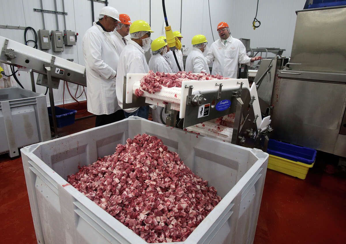 Pork meat cubes fall into a bin Monday April 13, 2015 at Labatt Food Service's Direct Source Meats in San Antonio as a tour is given to people from Native American Indian territories and others. Labatt Food Service is leading an effort to make Navajo and other Native Americans niche players in the beef industry.