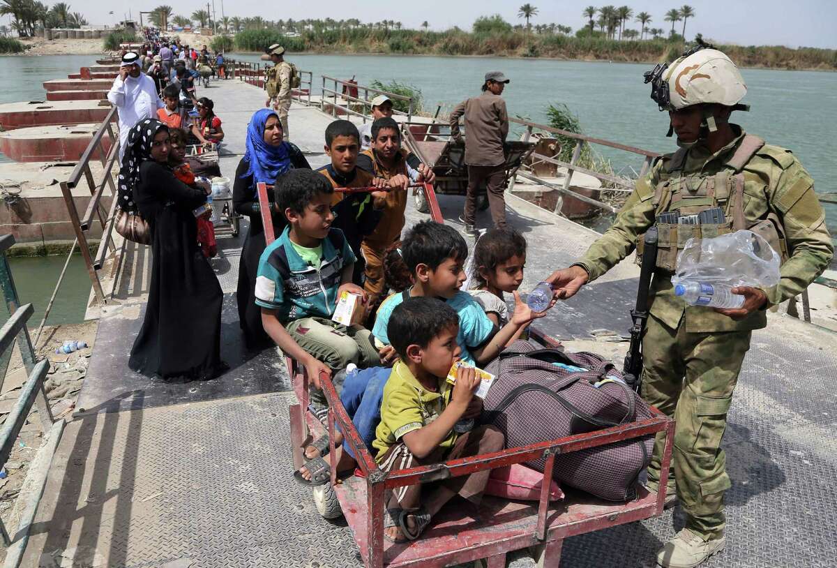 Iraqi security troops distribute bottles of water to families fleeing Ramadi. Thousands of displaced people continue to pour into Baghdad, fleeing the ongoing fighting in Anbar province’s capital between Iraqi security forces and Islamic State fighters.