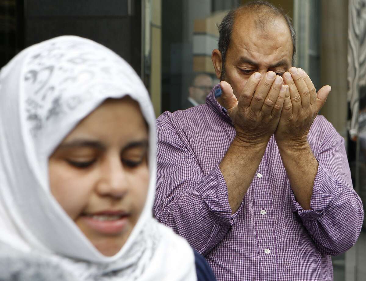 Naeema Omar speaks about her father Mosed Omar (right) during a news conference outside the Federal Building, Monday, April 20, 2015, in San Francisco, Calif. Mosed, age 64, of S.F., was stranded in Yemen for 14 months after his passport was revoked by the U.S. Embassy under mysterious circumstances. He went to Yemen to help his youngest daughter, 15-year-old Karama, obtain a passport. Mosed was later given a one-way travel document to the U.S. He has filed a lawsuit against Secretary of State John Kerry and the State Department. Karama remains in Yemen.