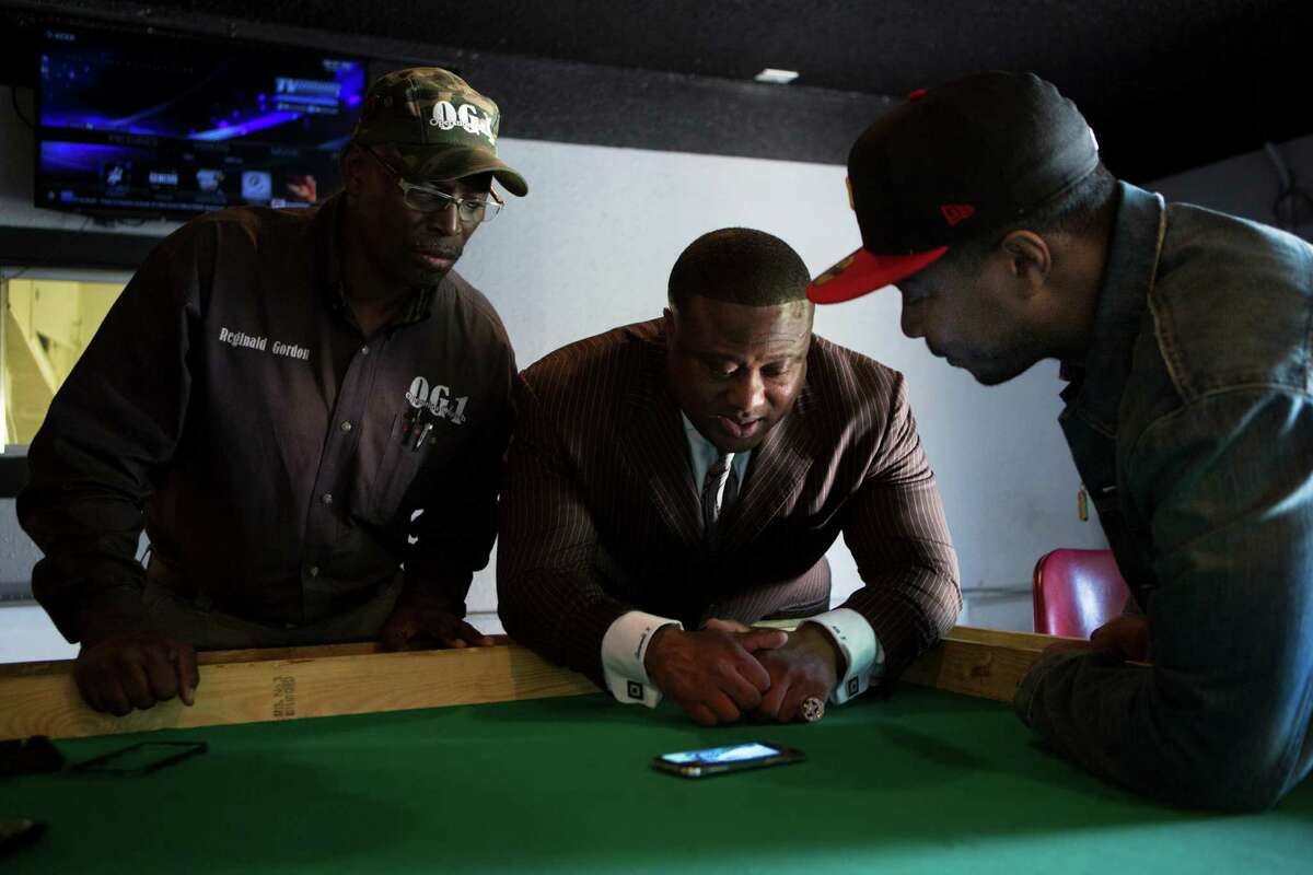 Reginald Gordon, left, community activist Quanell?…X and Marquette Jones, owner of a game room business, watch a video that captured uniformed officers allegedly breaking in to Jones' business.