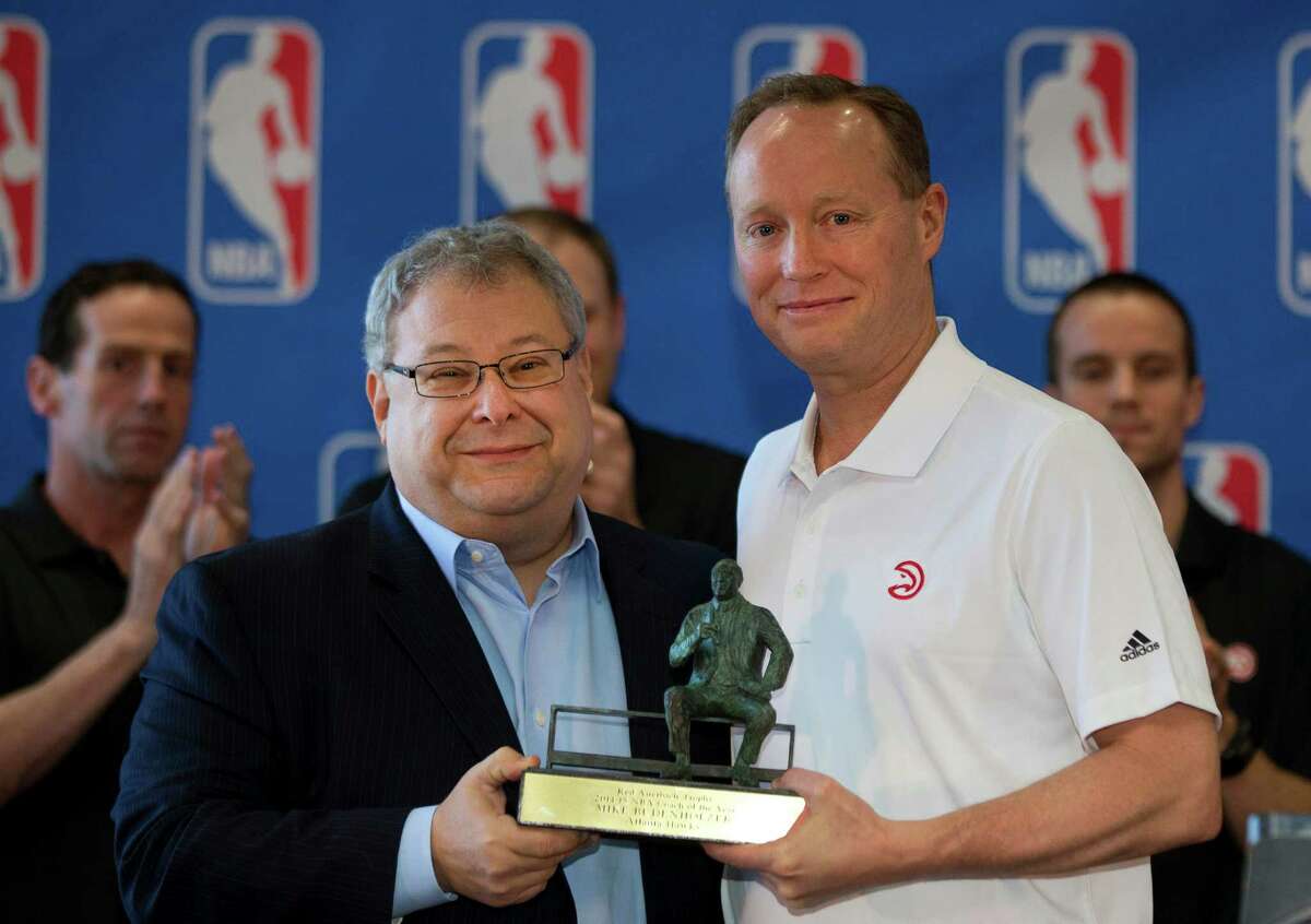 Atlanta Hawks CEO Steven Koonin, left, presents Atlanta Hawks head coach Mike Budenholzer with the Red Auerbach Trophy for NBA coach of the Year during a basketball news conference, Tuesday, April 21, 2015, in Atlanta. (AP Photo/John Bazemore)