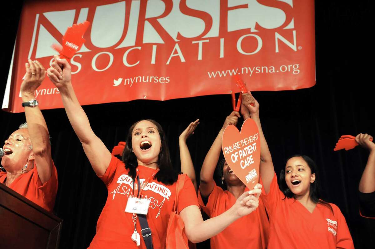 Minerva Solla of the New York State Nurses Assoc., left, joins nurse members on stage during a rally to advocate for patients' healthcare needs on Tuesday, April 21, 2015, at the Empire State Plaza Convention Center in Albany, N.Y. (Cindy Schultz / Times Union)